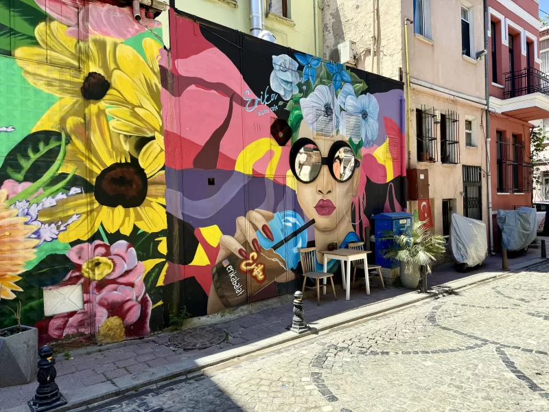 Grafiti na stěně ve čtvrti Balat v Istanbulu. Na grafitti je žena s brýlemi místo kterých jsou zrcadla.