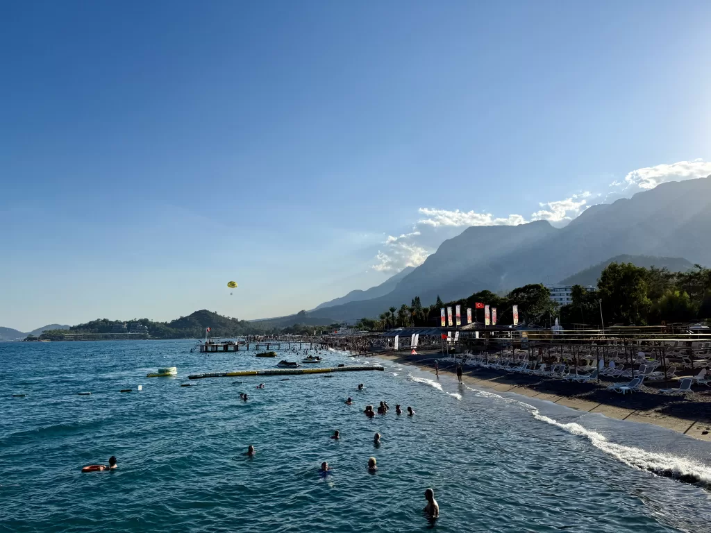 Moře, hory, lidé koupající se v moři